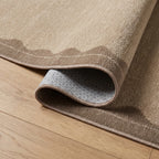 Orla Tan Rug corner folded back showing the bound edge and non slip backing